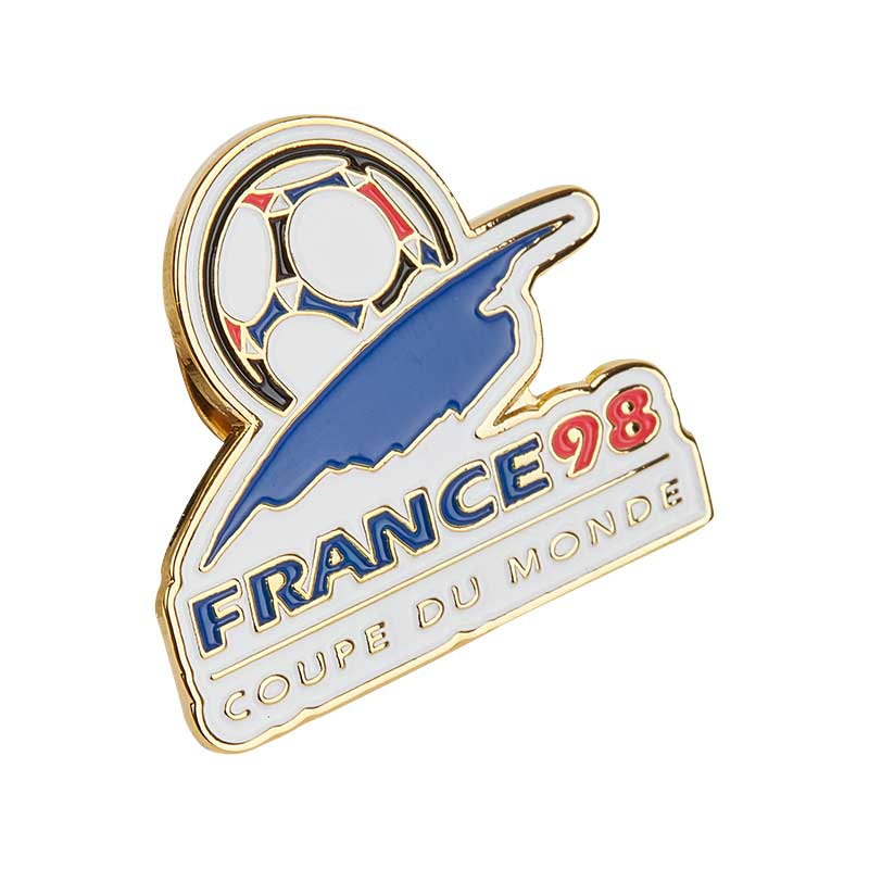 White retro pin with blue, red, black elements, and golden borders, representing the celebration of the FIFA World Cup in 1998 in France.