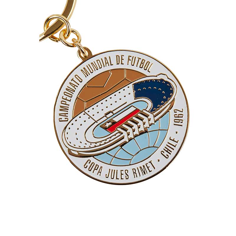 Round keyring in white & blue with a stadium in the middle & the Chilean flag, representing the FIFA World Cup celebration in 1962 in Chile.