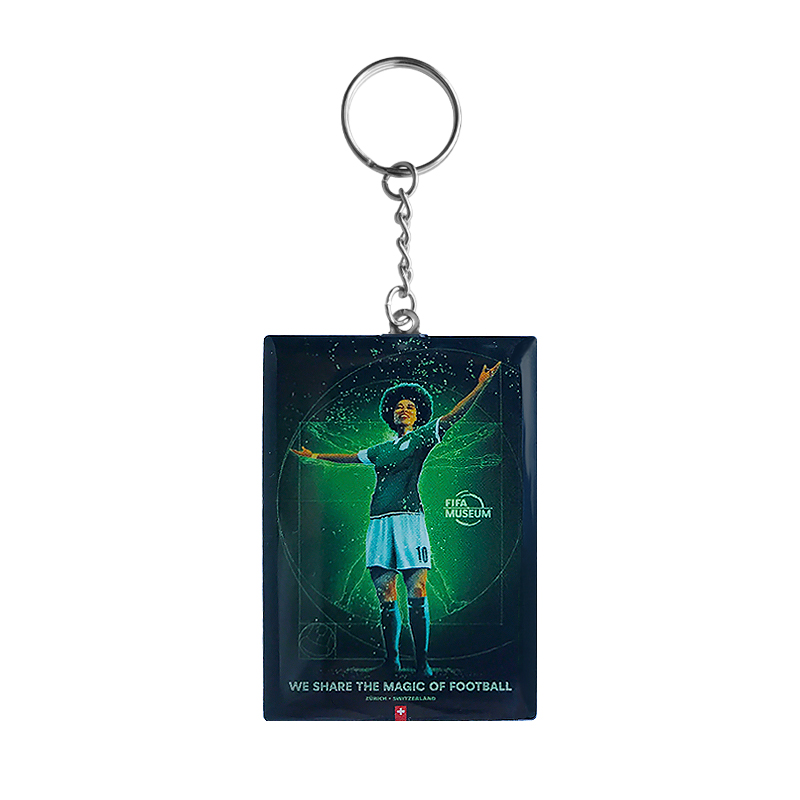 A green keyring with an image of a woman football player, the text 'We share the magic of football' and The FIFA Museum logo.